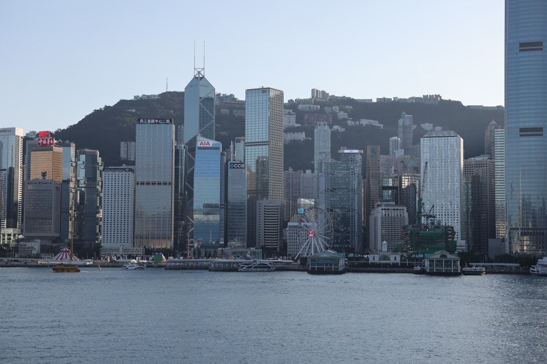Modern skyscrapers rise behind a harbor in hong kong.