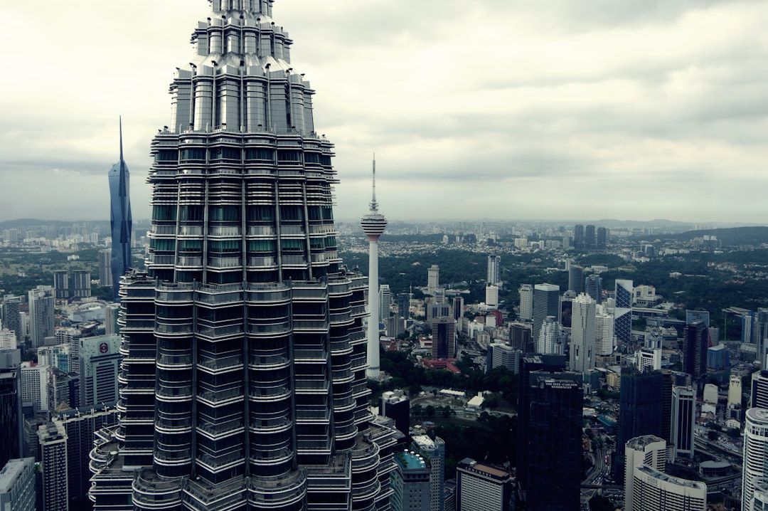 Modern skyscrapers in a sprawling cityscape under a cloudy sky