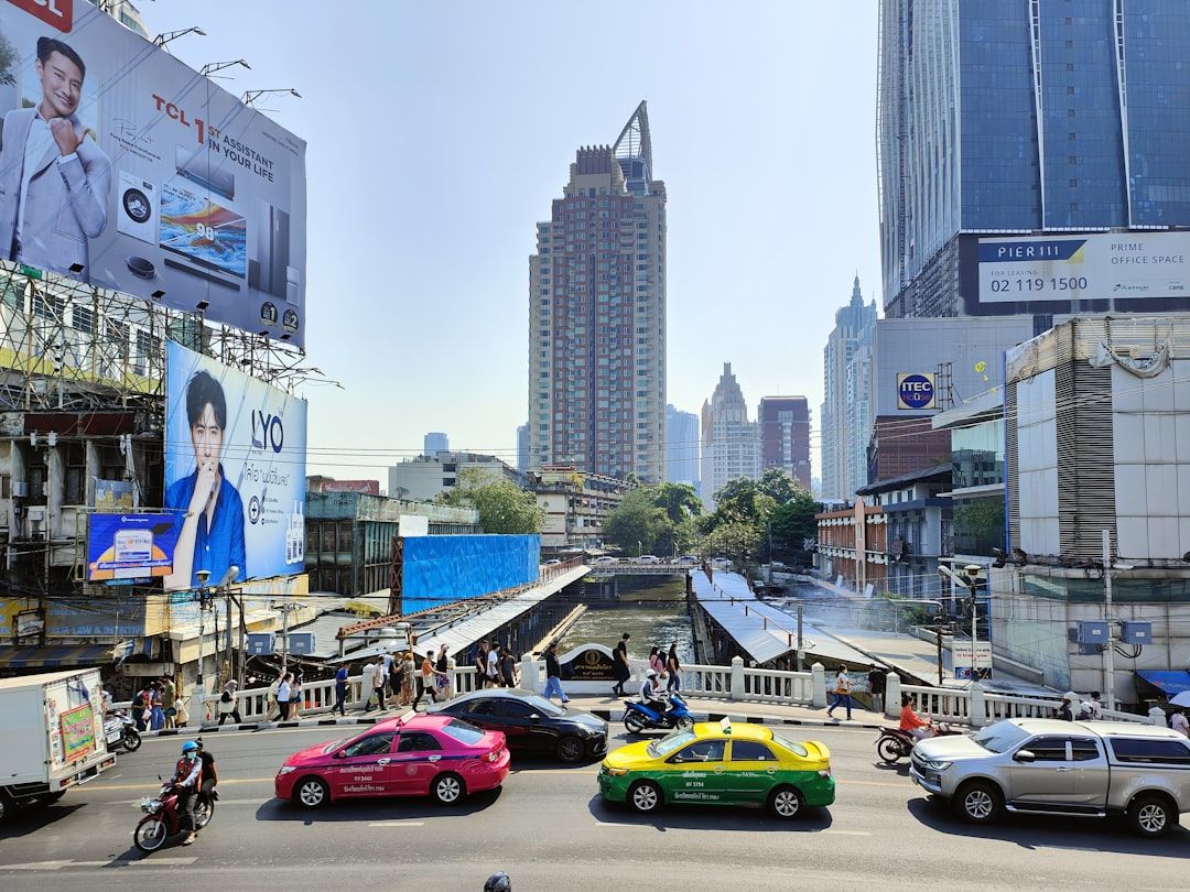 a city street filled with lots of traffic next to tall buildings