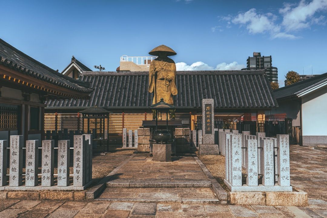 Golden statue in front of traditional japanese building