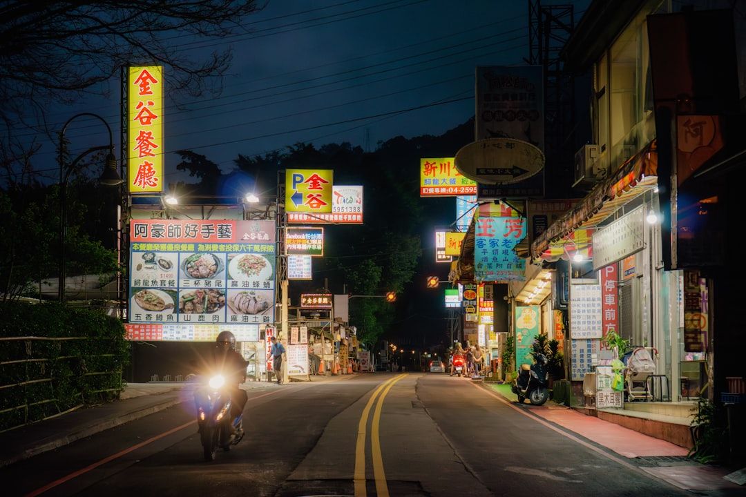 Nighttime scene of a road with signs and lights.