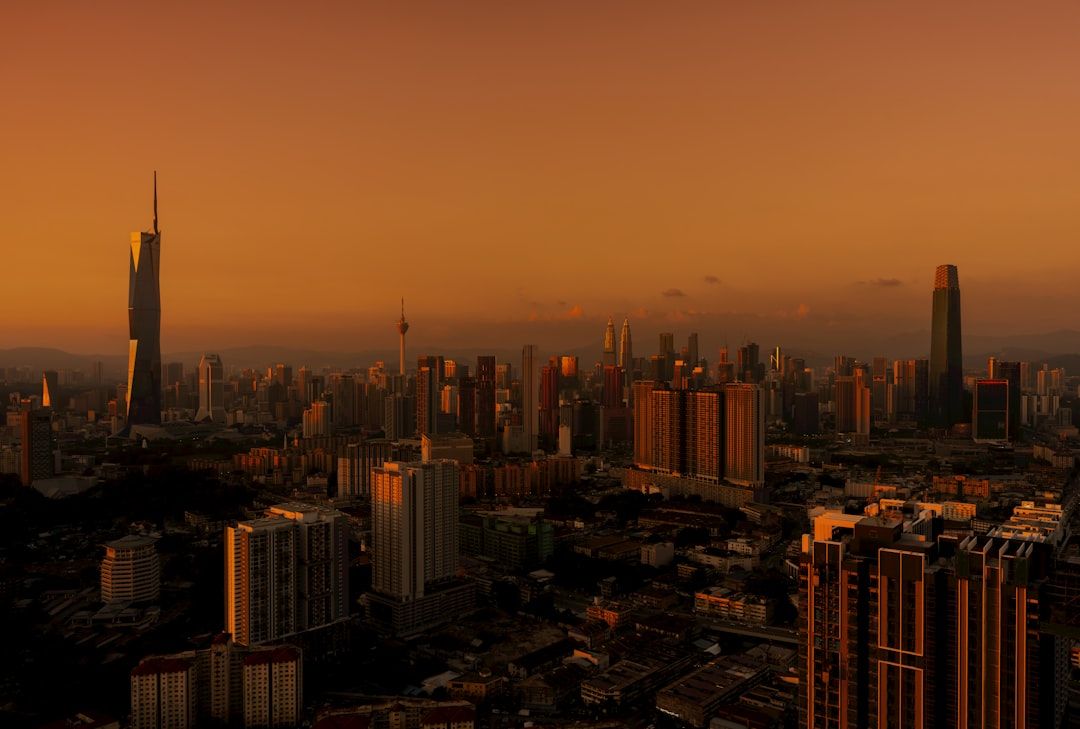 City skyline at sunset with warm orange sky.