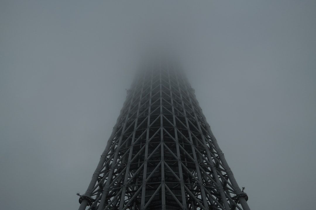 Tall metal tower disappearing into fog