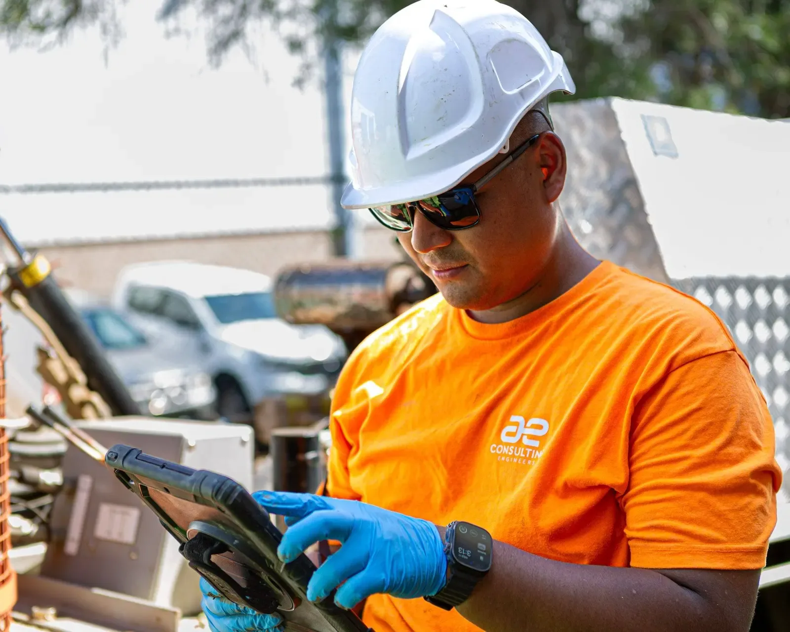 A tradesman in an orange work shirt on a building site