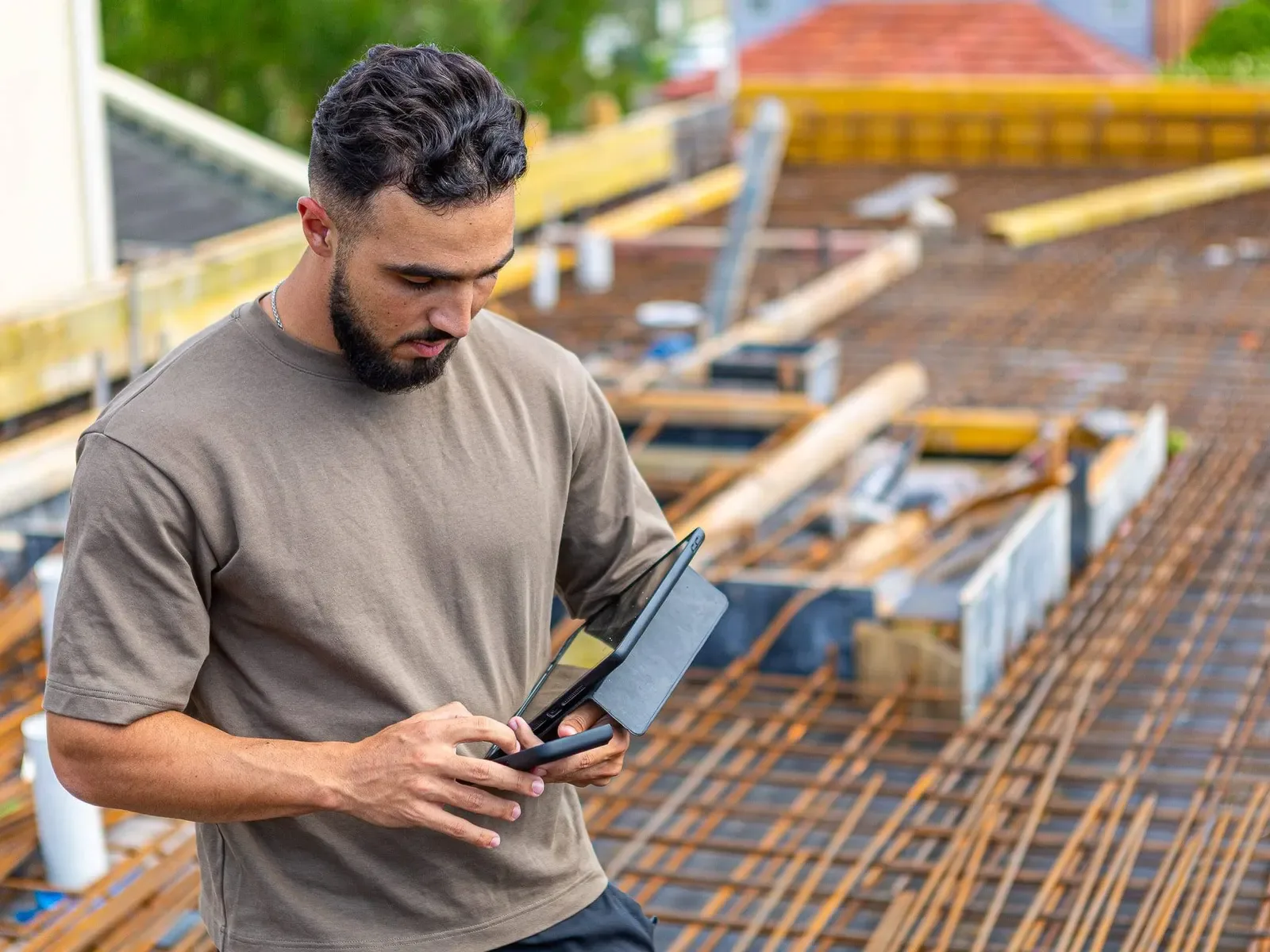 A man on a construction site checking his phone