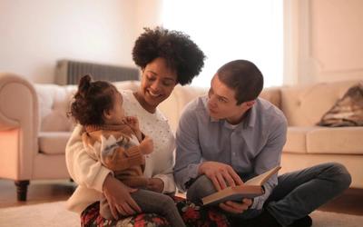two parents reading to an toddler