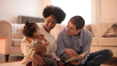 two parents reading to an toddler