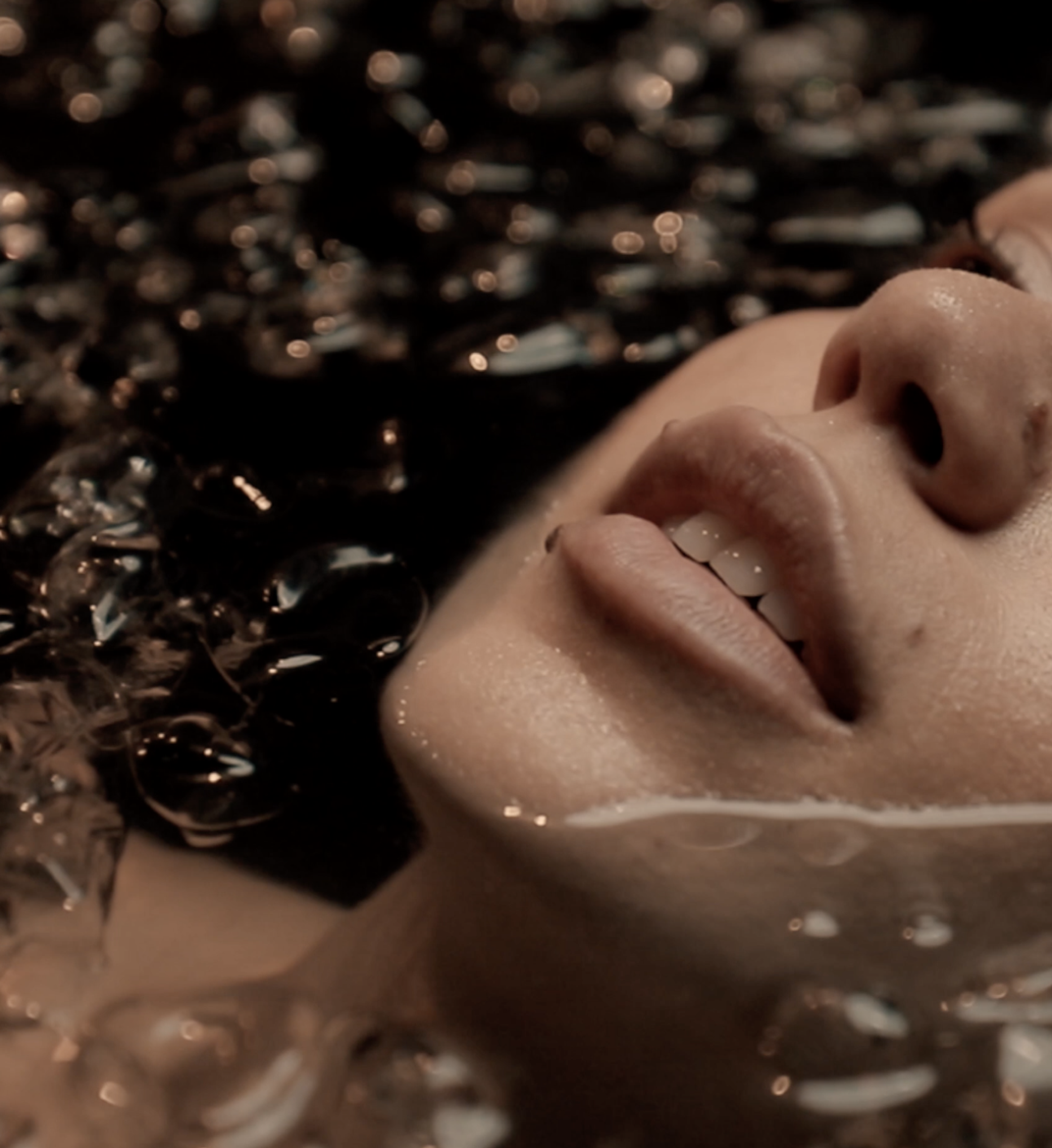 Close up of a woman's face floating in ice water