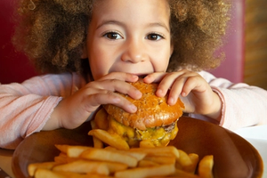 child eating burger and fries