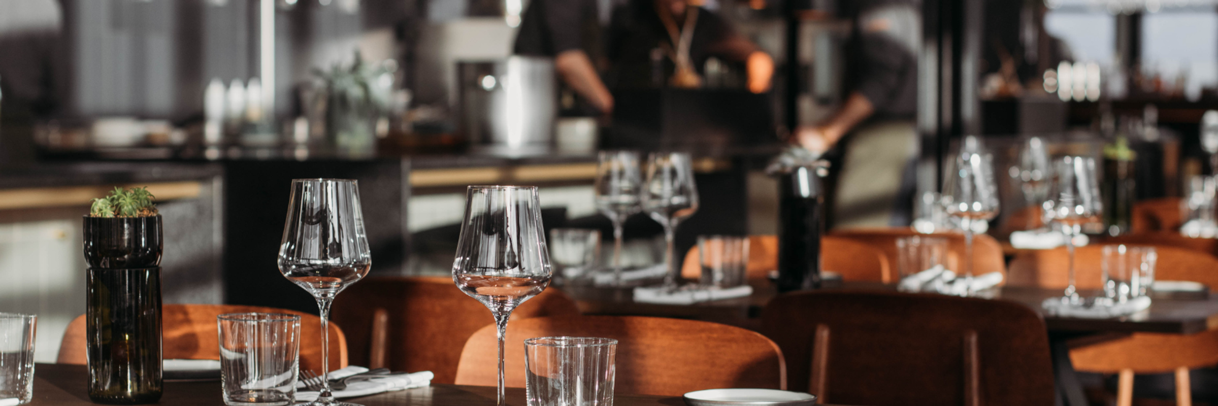 Wine glasses on wooden tables inside restaurant