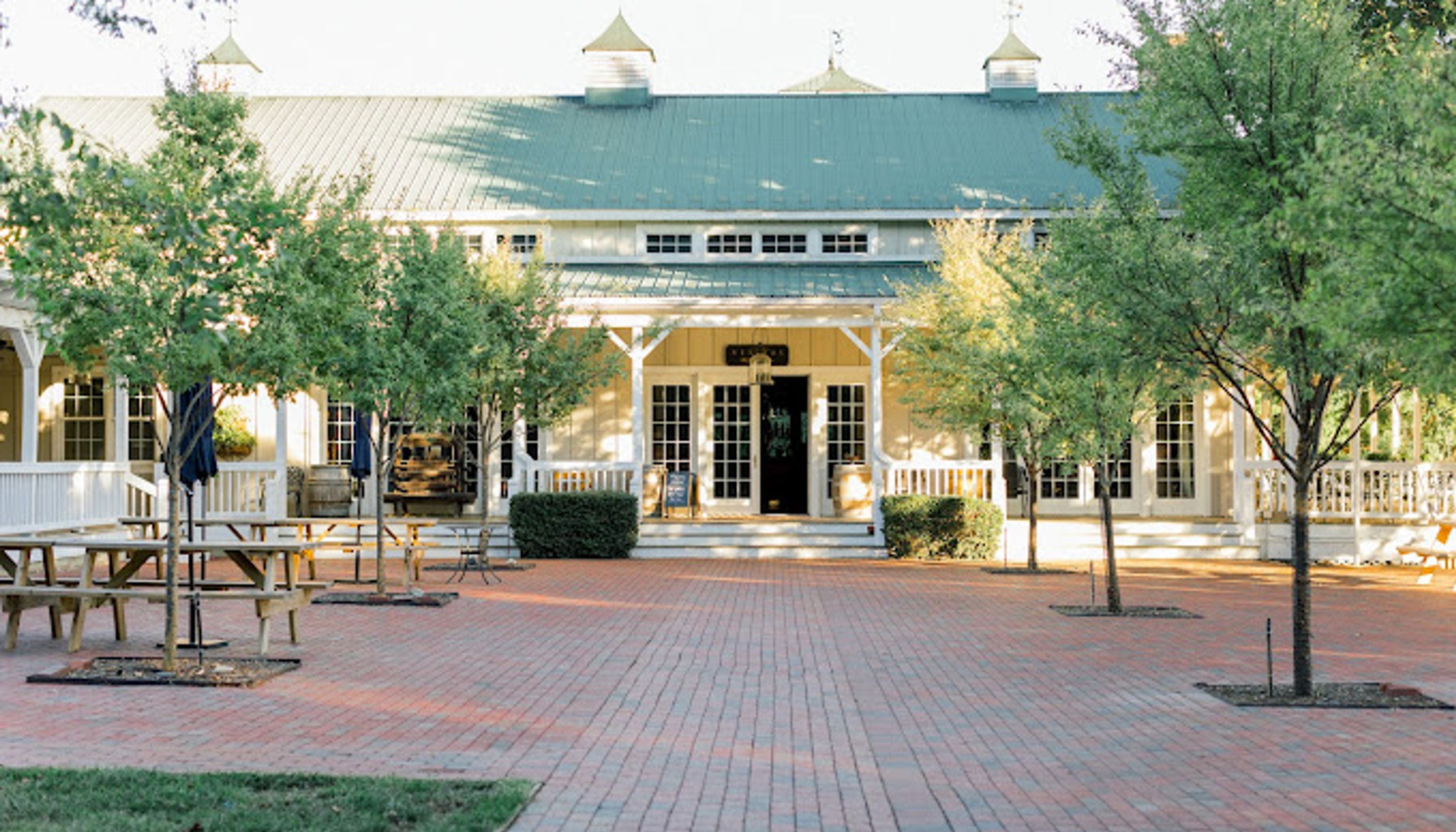 brick patio in front of white building with green roofundefined