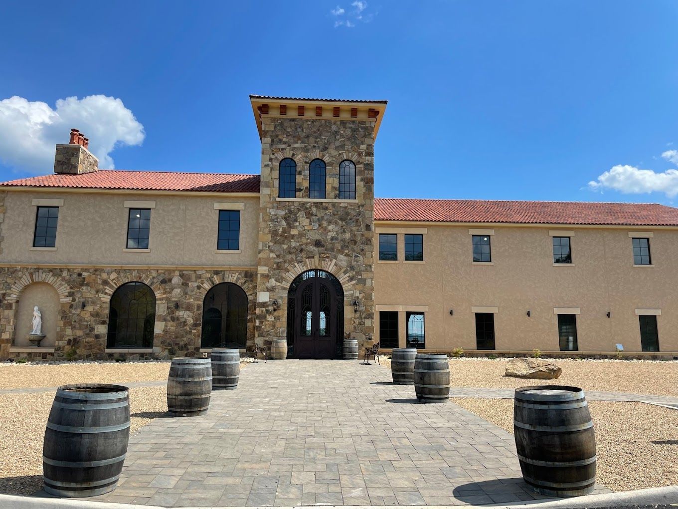 Building with stone features, rounded windows and red roof