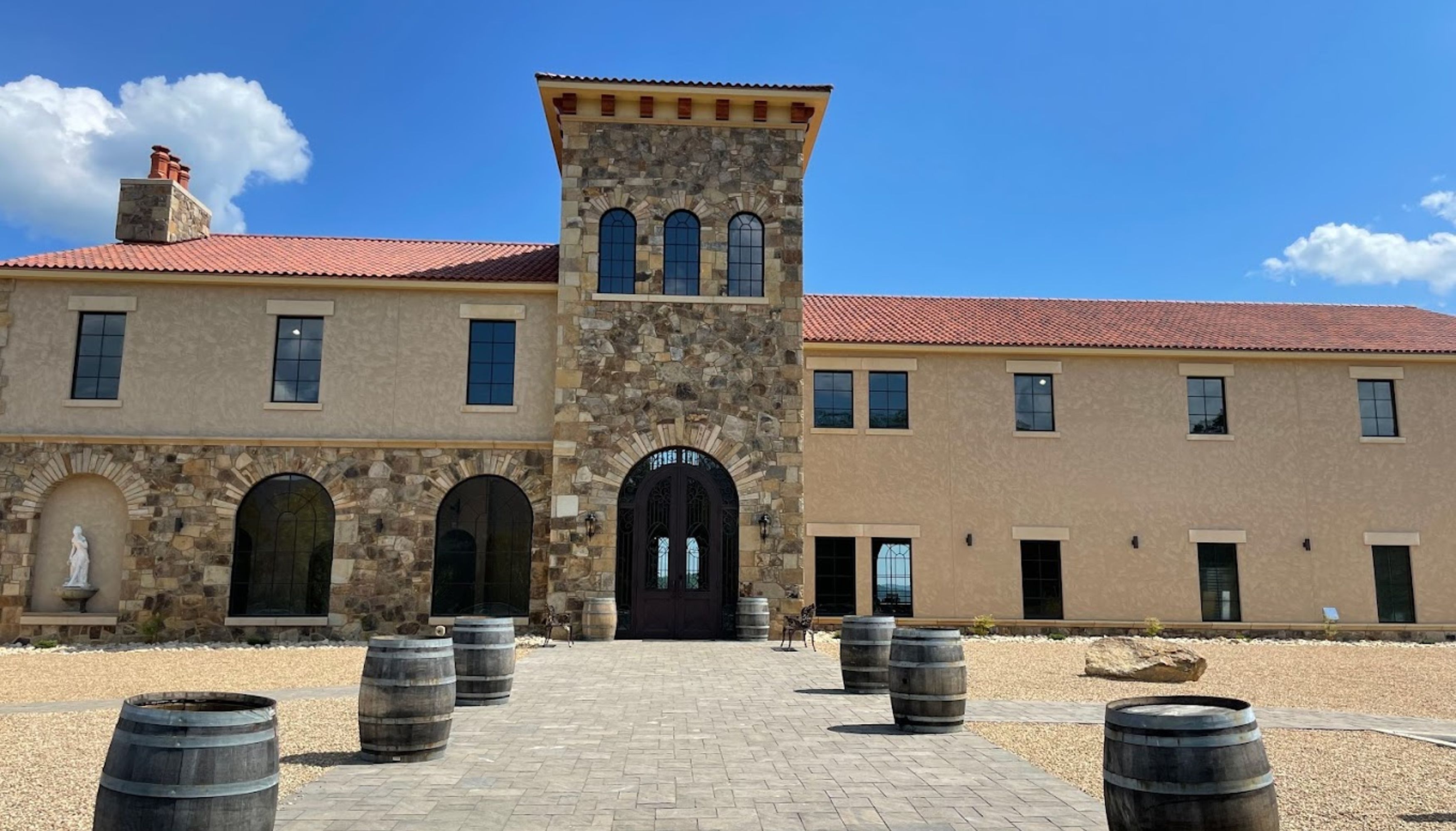 Building with stone features, rounded windows and red roof