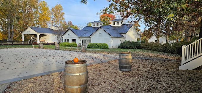 white building behind parking lot scattered with fall leaves