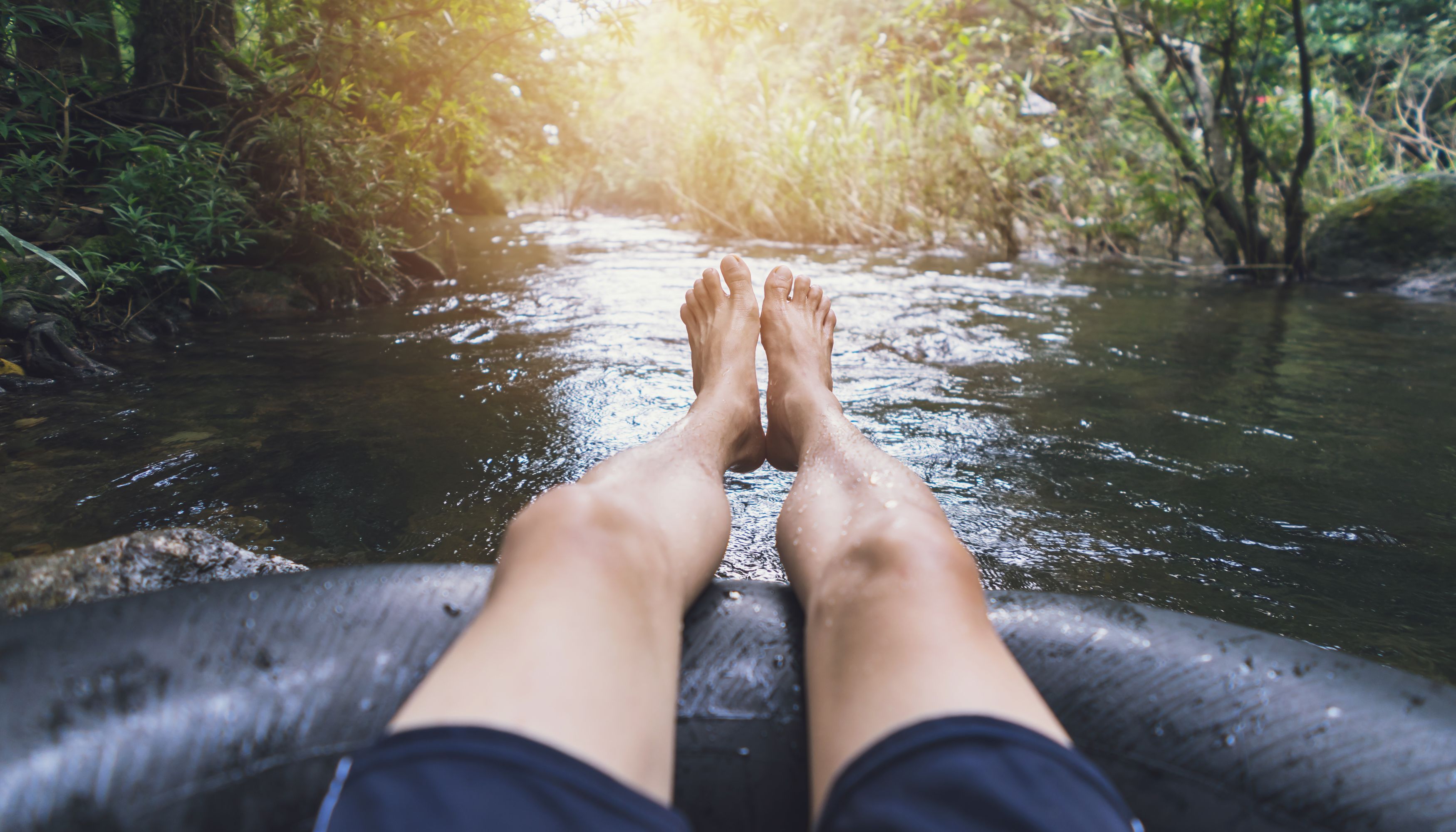 Man with feet out tubing on riverundefined