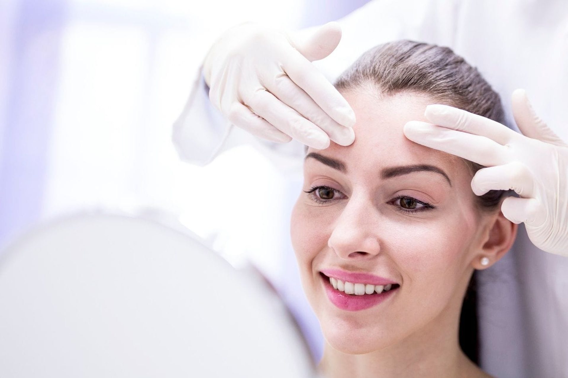 Woman smiling during a forehead treatment