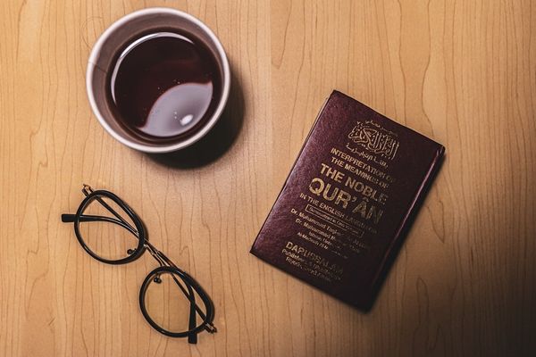 black framed eyeglasses beside purple book
