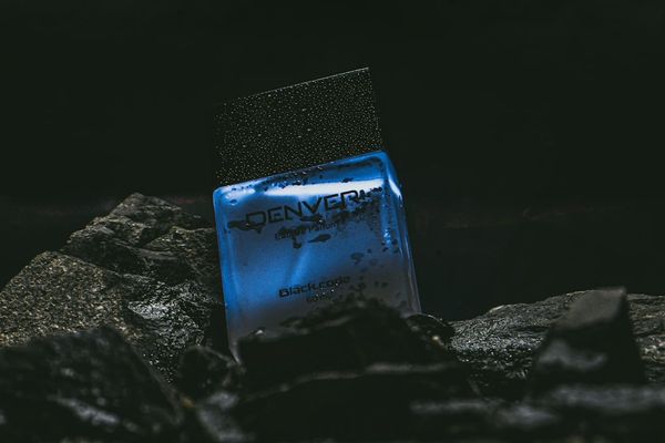 a blue bottle sitting on top of a pile of rocks