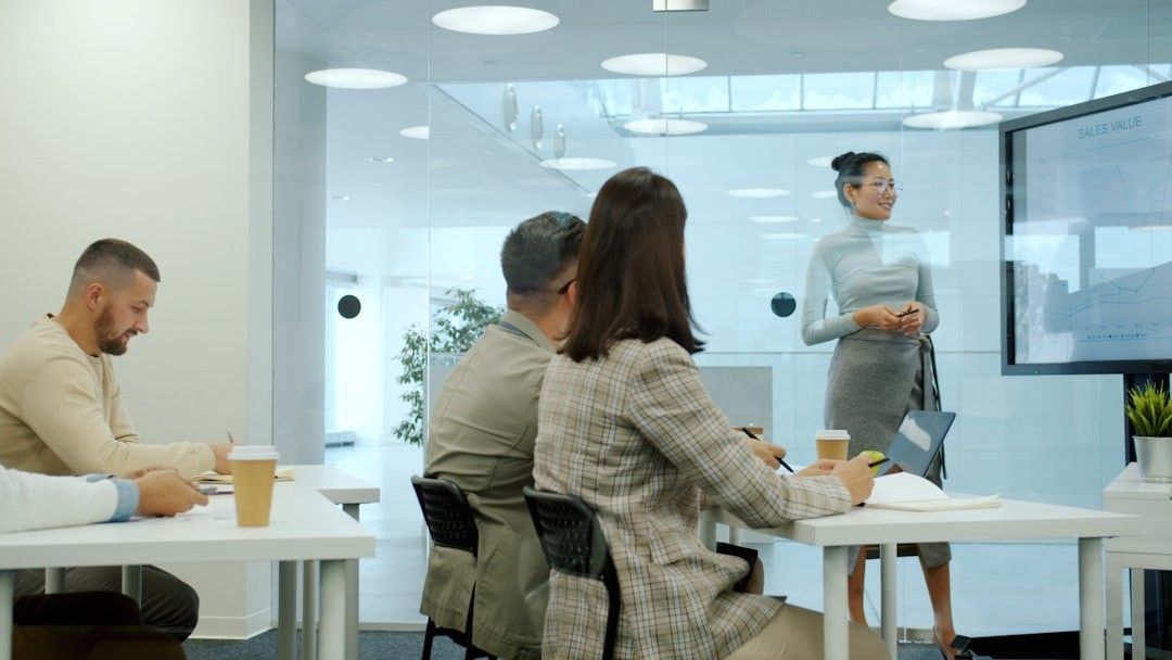 Woman presenting to colleagues in a modern office meeting.