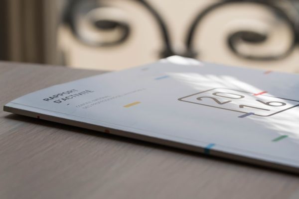 person taking a photo of white book on table