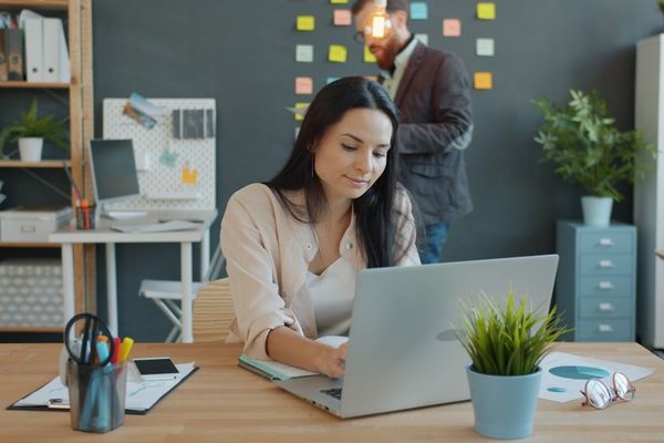 Woman working on laptop in modern office environment