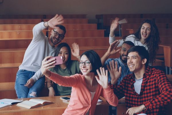 Students taking a selfie in a lecture hall.