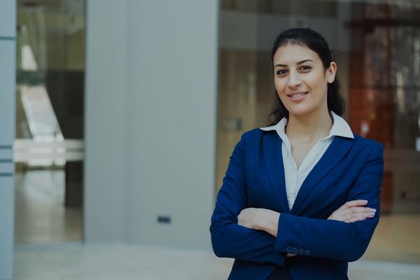 A confident businesswoman in a blue suit smiles.