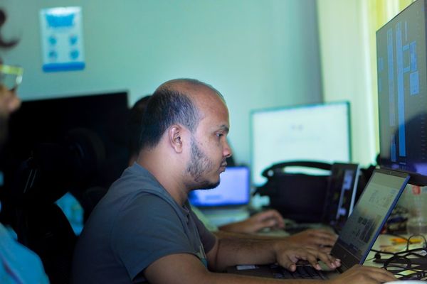 Man working on a laptop in an office setting.
