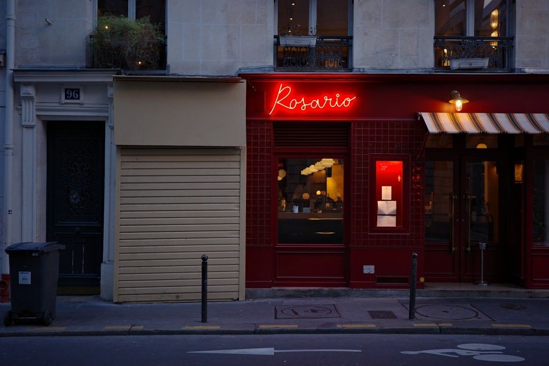 A red storefront with a neon sign that says rosario