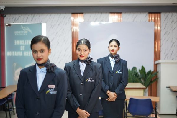 Three women in uniform stand in a classroom.