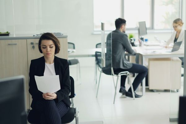 Woman sitting in office holding papers