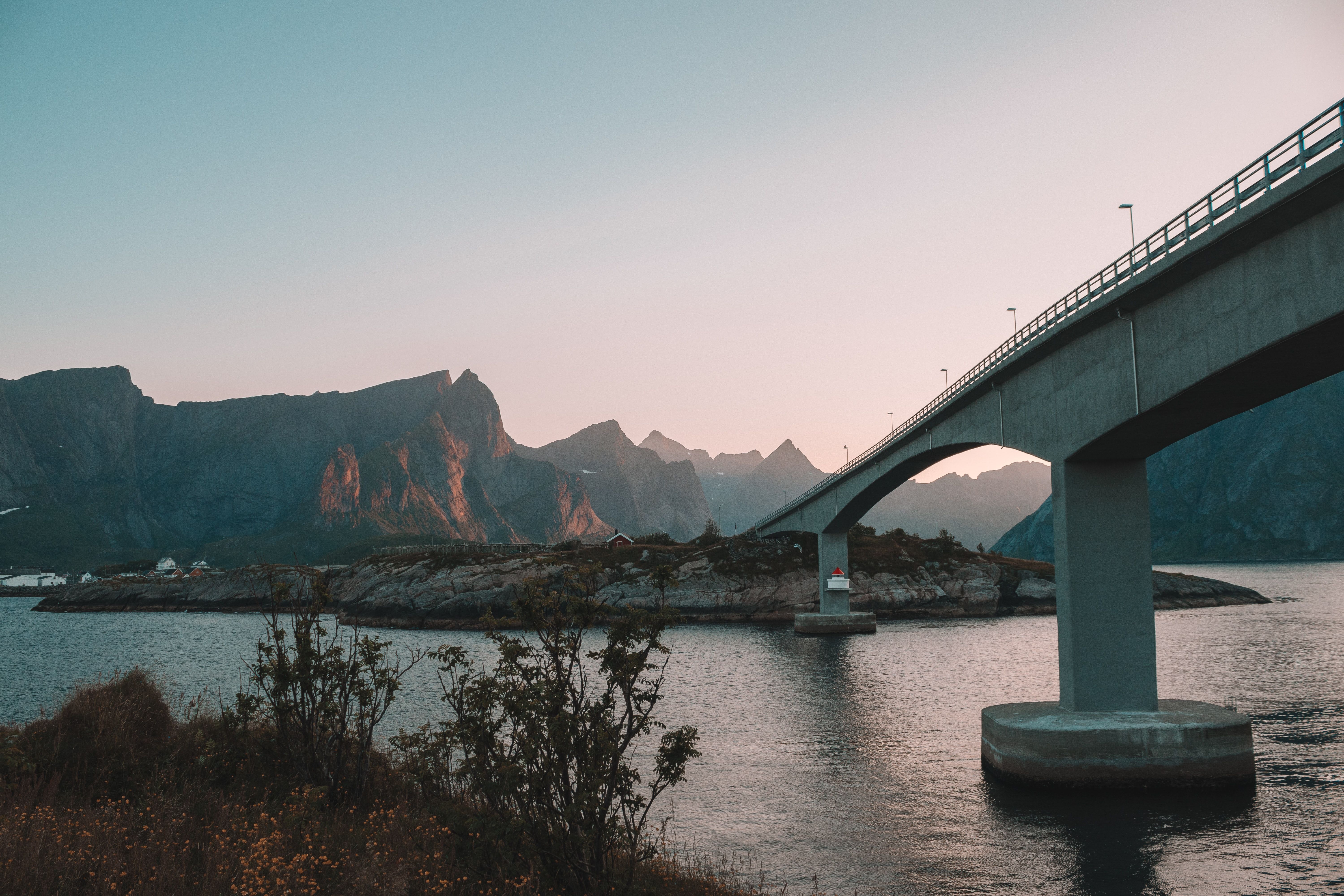 Eine Brücke über eine Meerenge mit einem Hintergrund von Bergen