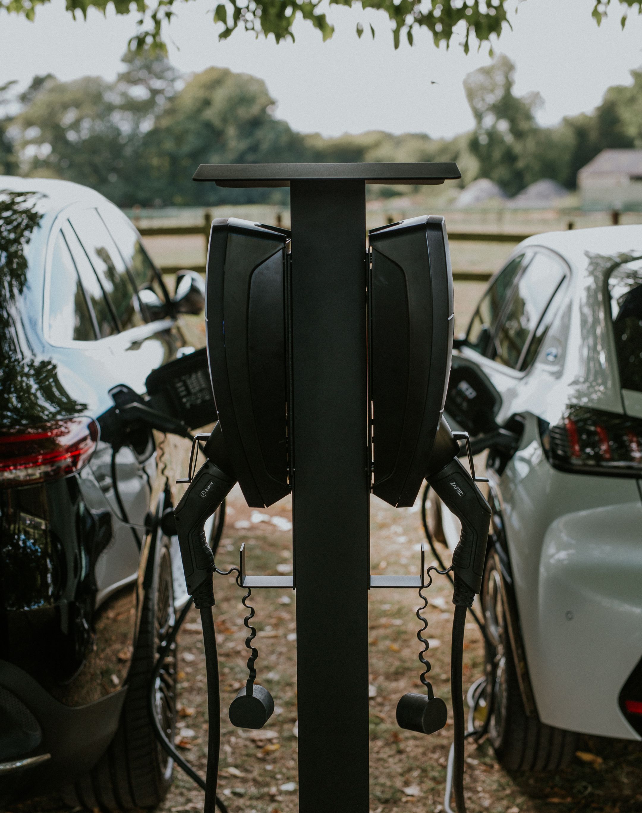 Mann steckt E-Auto an Ladestation ein