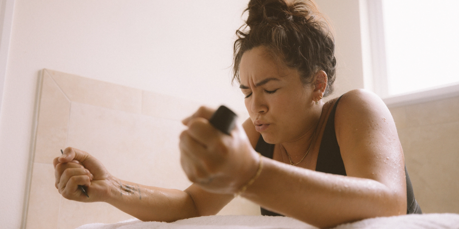 Pregnant mother, who completed the Momday pregnancy workout program, preparing for labor and squeezing hands tightly.