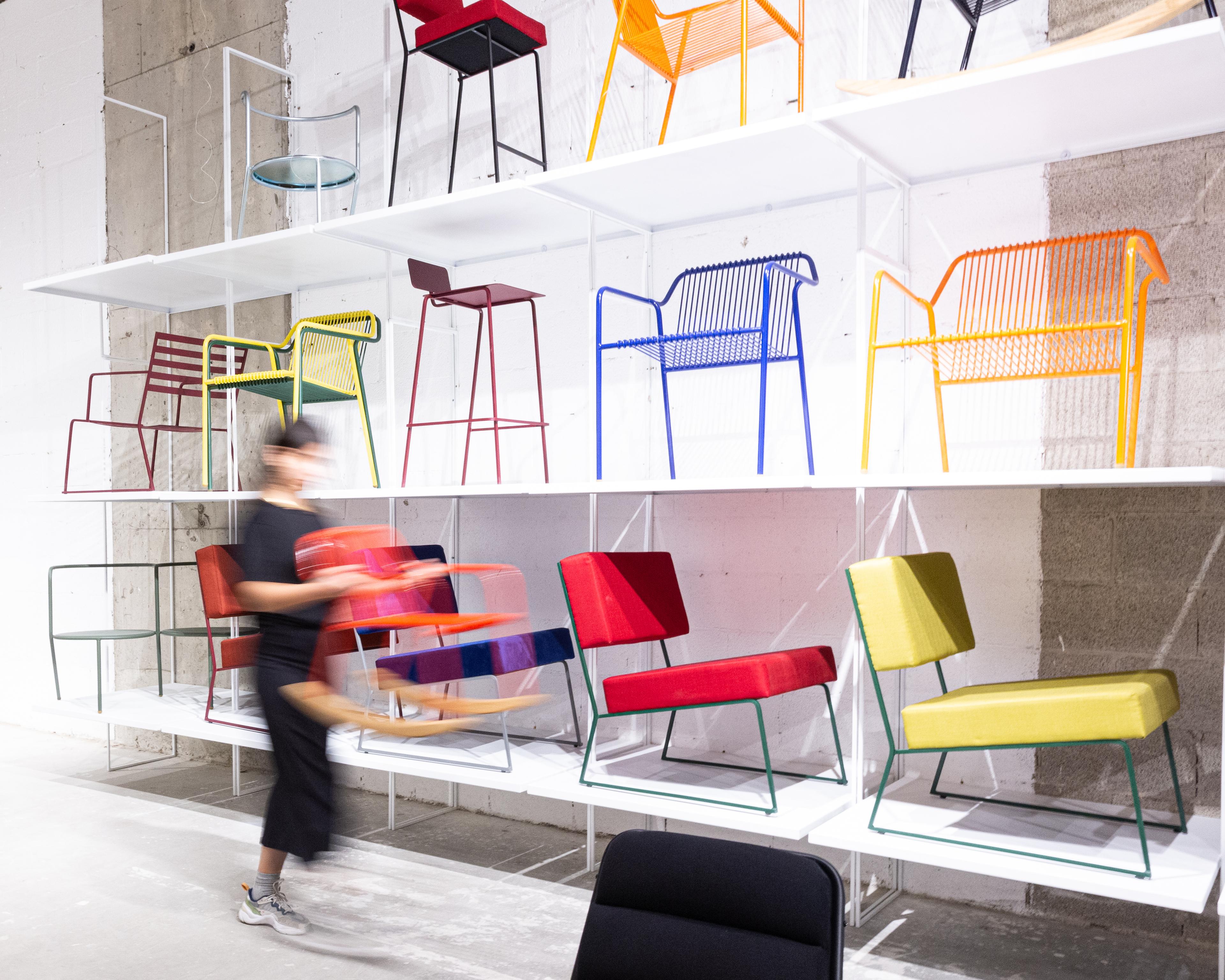 Photo of multiple chairs arranged on a large ceiling high shelf