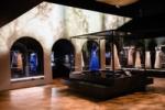 Image shows a view of the gallery, The Expression Of A Stark Luxury , with a blue and pink dress on display. The scene design reference's Chanel's house La Pausa. From Gabrielle Chanel. Fashion Manifesto at the V&A Museum London. Soundscape by Coda to Coda.