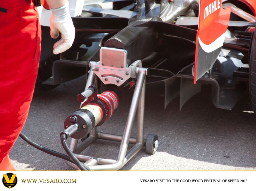 Rear of an F1 car in the Goodwood paddock with a mechanic and a starter jack at the gearbox