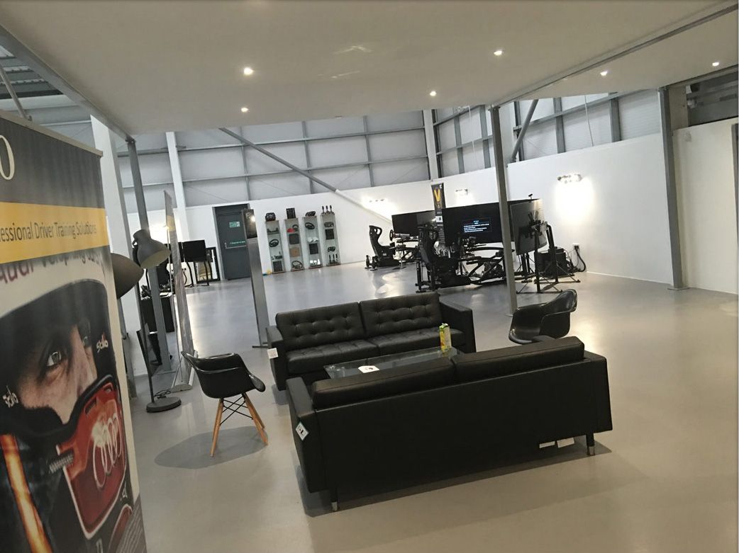 Open-plan Vesaro showroom with sofas in the foreground and simulator rigs set up towards the back