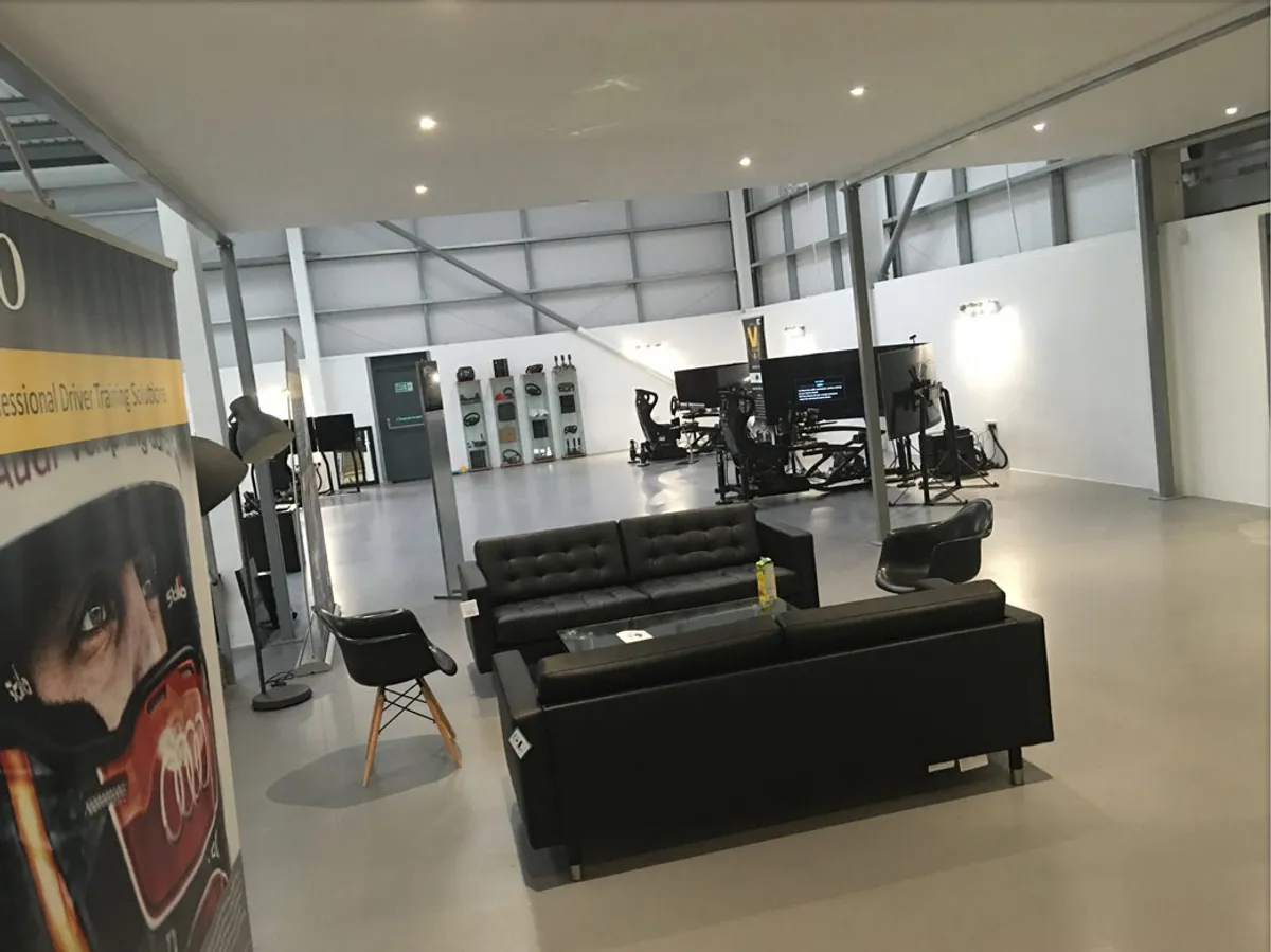Open-plan Vesaro showroom with sofas in the foreground and simulator rigs set up towards the back