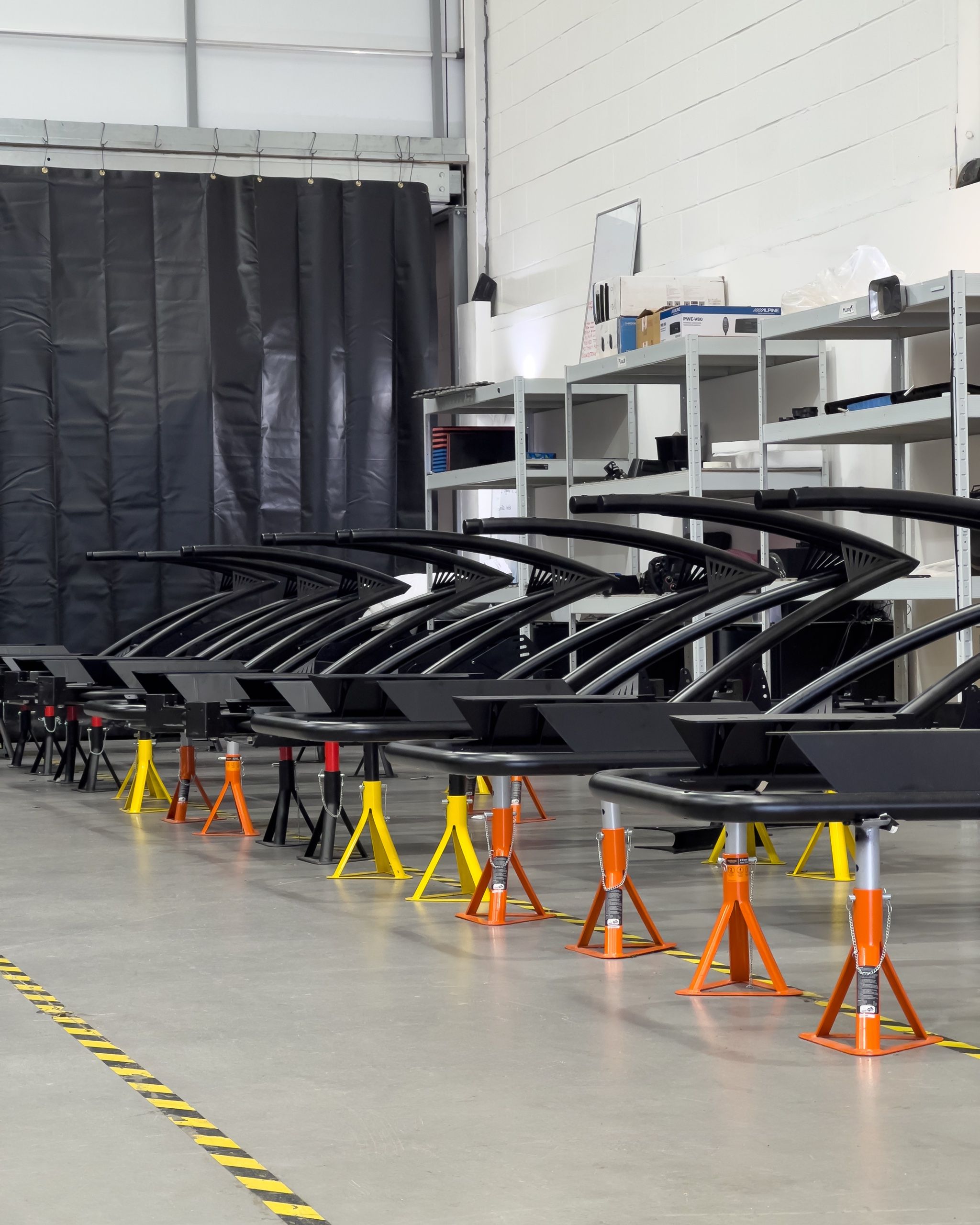 Row of finished Vesaro chassis frames on stands on the factory floor