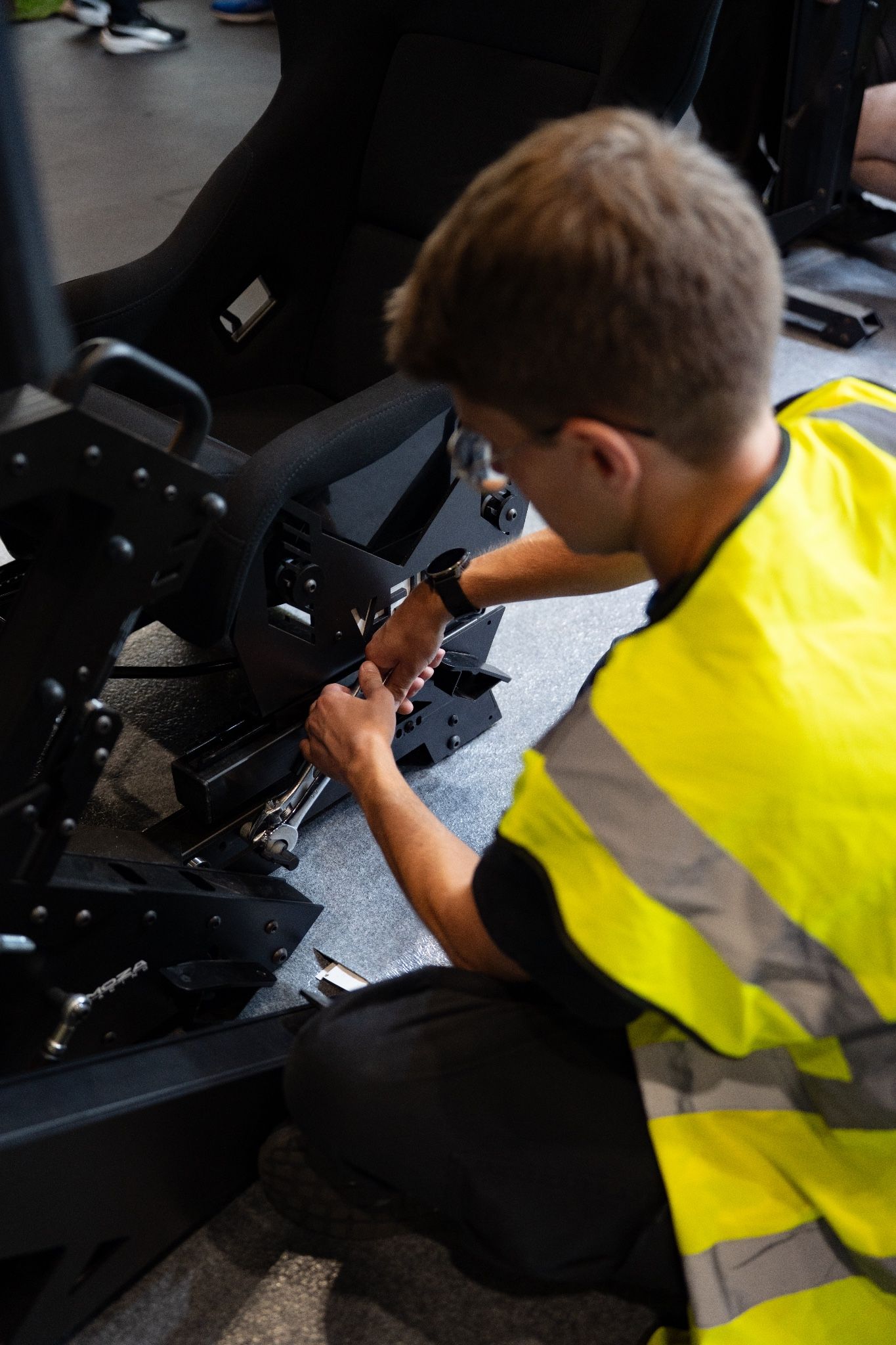 Team member fitting components to a simulator chassis