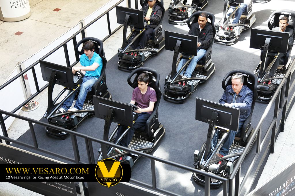 Overhead view of five people driving Vesaro simulators with single monitors in a roped-off shopping centre area