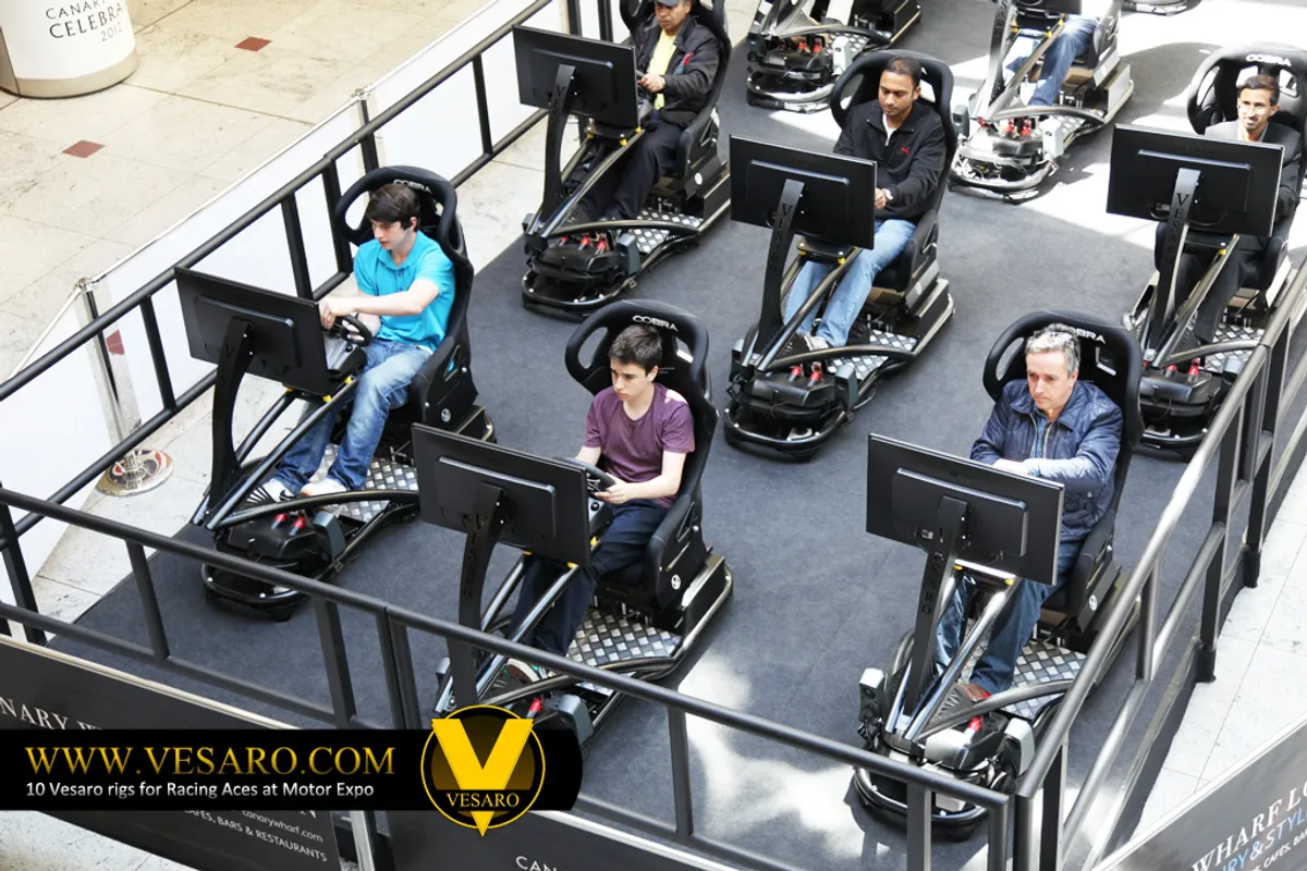 Overhead view of five people driving Vesaro simulators with single monitors in a roped-off shopping centre area