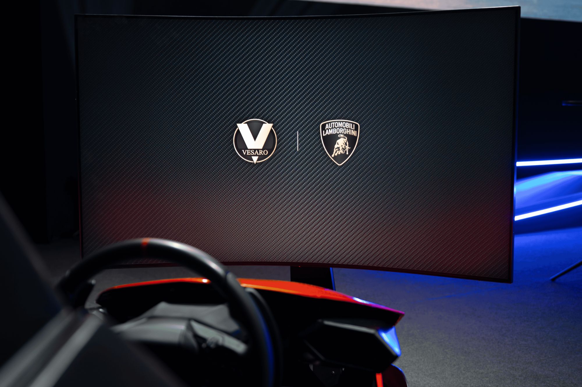 Curved display showing the Vesaro and Automobili Lamborghini logos above a wheel in a dark room with blue lighting