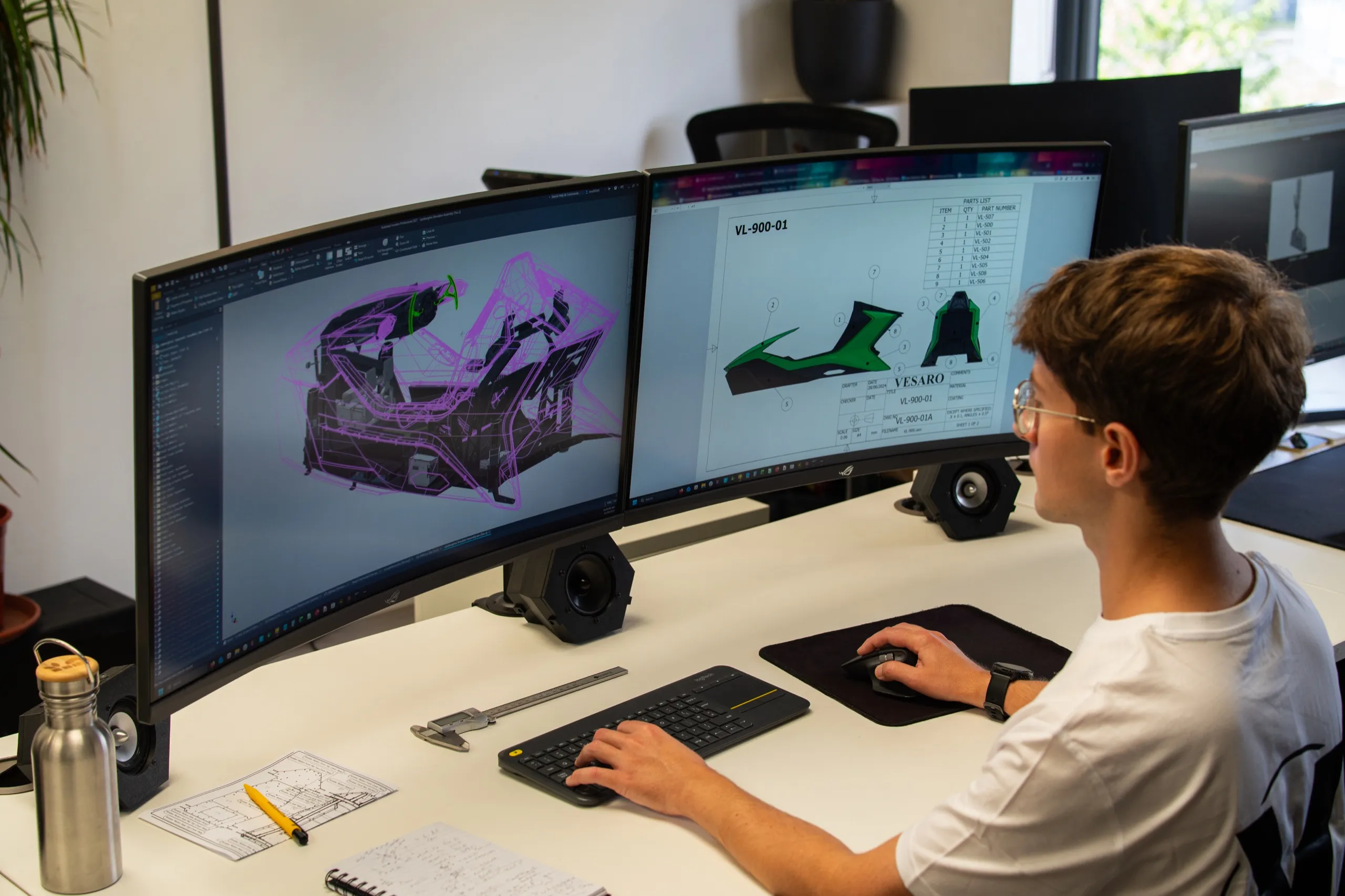 Vesaro CAD designer working on simulator technical drawings across dual monitors