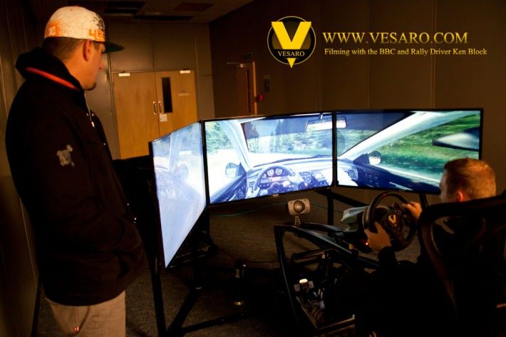 Rally driver Ken Block watching a driver on a Vesaro triple-screen simulator during BBC filming