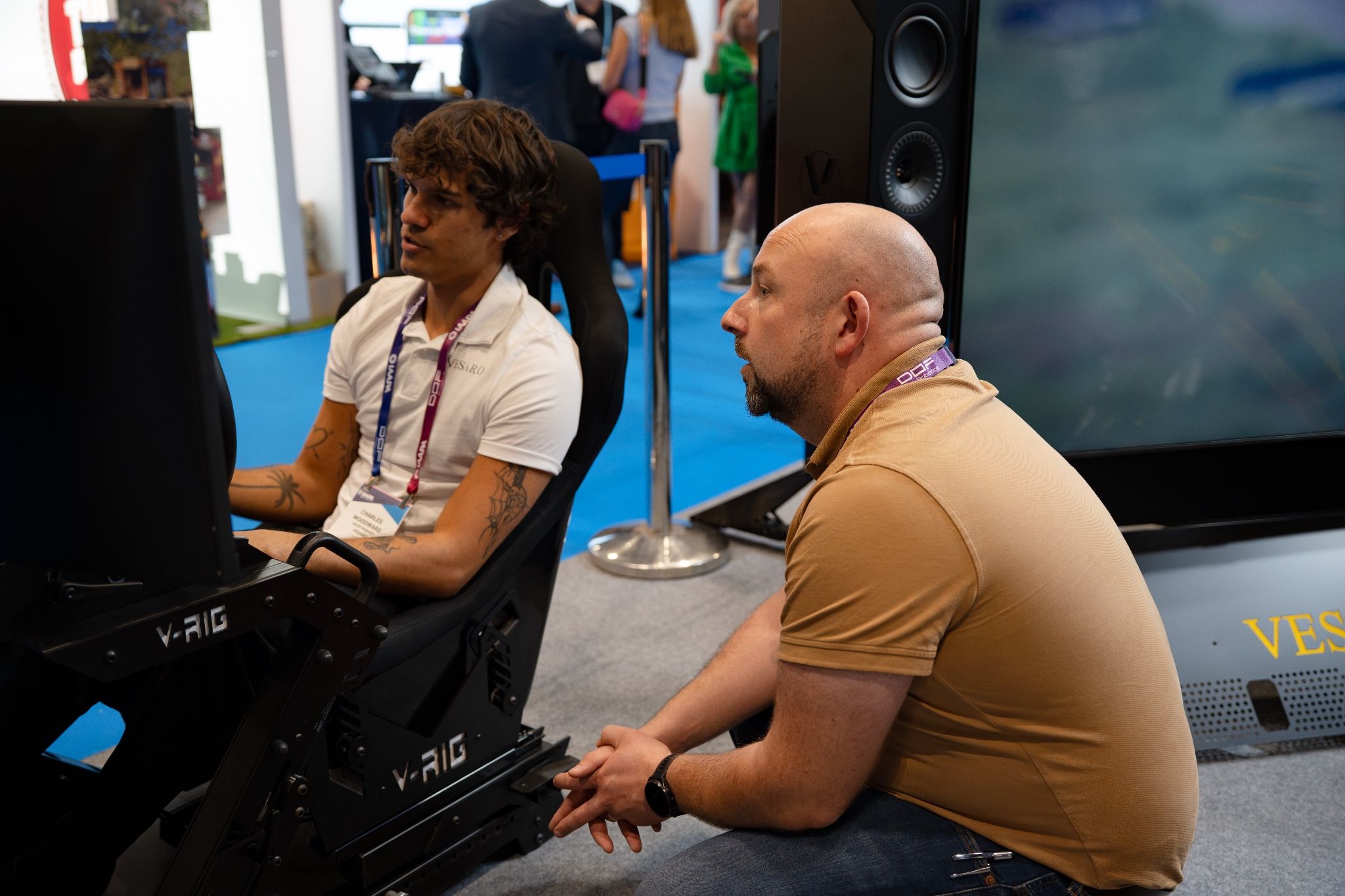 Visitor trying a V-RIG simulator with a member of the Vesaro team