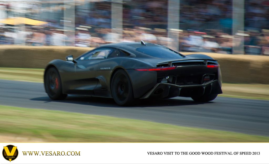 Black Jaguar hybrid supercar driving on the Goodwood hill course past crowds in 2013
