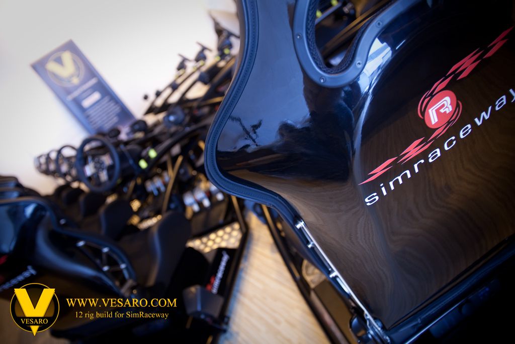 Simraceway-branded bucket seat in the foreground with a row of Vesaro simulator rigs and wheels behind