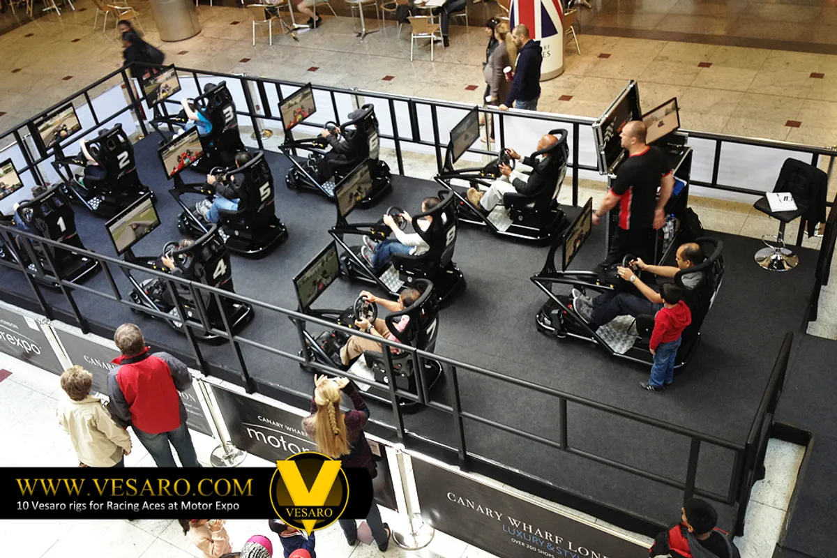 Elevated view of several drivers seated on Vesaro simulators with monitors in a Canary Wharf shopping centre